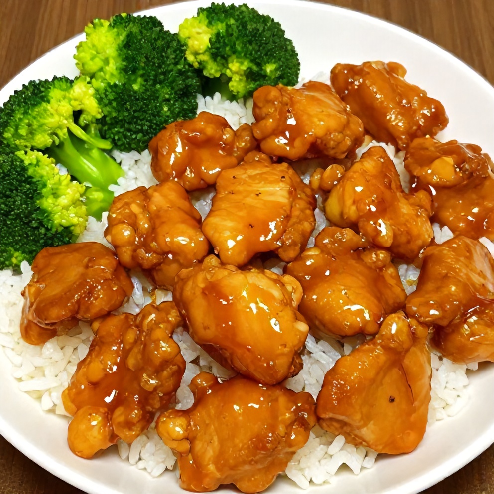 Plated orange chicken with steamed rice and broccoli