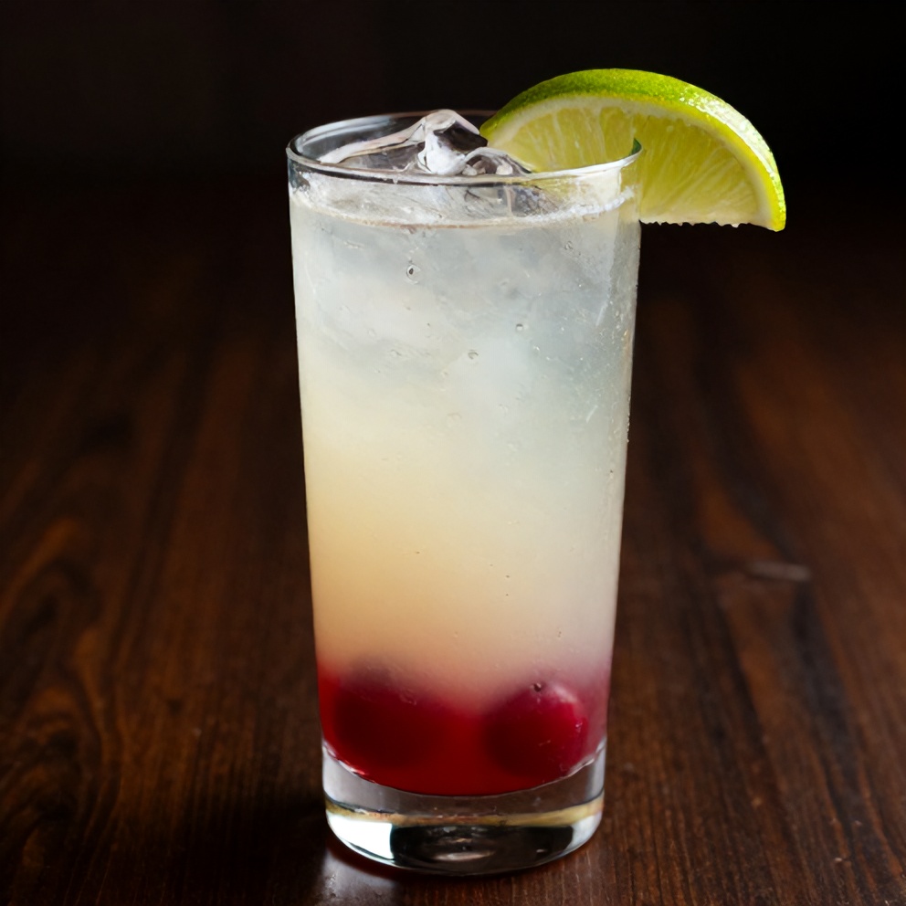 Cherry limeade in a glass with a lime wedge